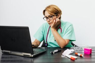 woman wearing eyeglasses while using her laptop