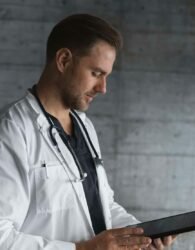 man in white button up shirt holding black tablet computer